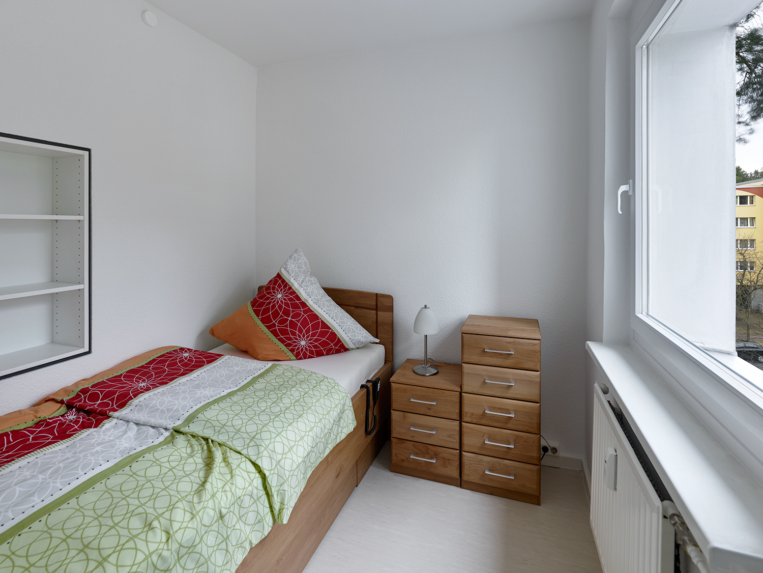 Schlafzimmer mit Bett Nachtisch und Regal