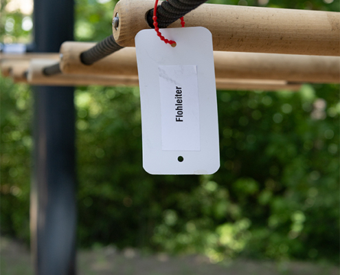 2.7.2026 // Flohleiter 2.7.2026, Detailfoto von einer Kletternlage, Anhänger an einem Seil mit der Aufschrift Flohleiter
