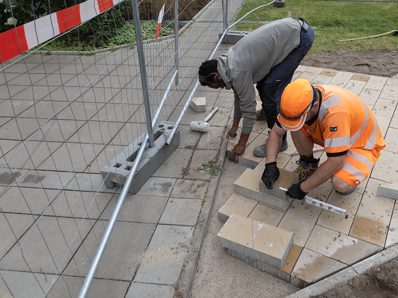 7.7.2026 // Die letzten Betonsteine des Hauptweges. 7.7.2026, zwei GaLa-Bauer vermessen und verlegen die letzten Betonsteine des Hauptweges